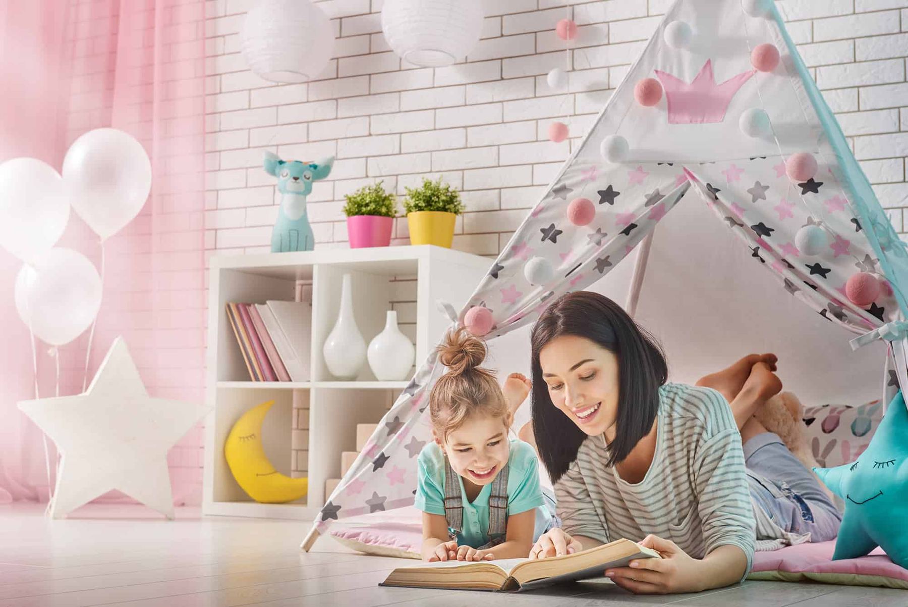 Mother and daughter reading inside a kids teepee